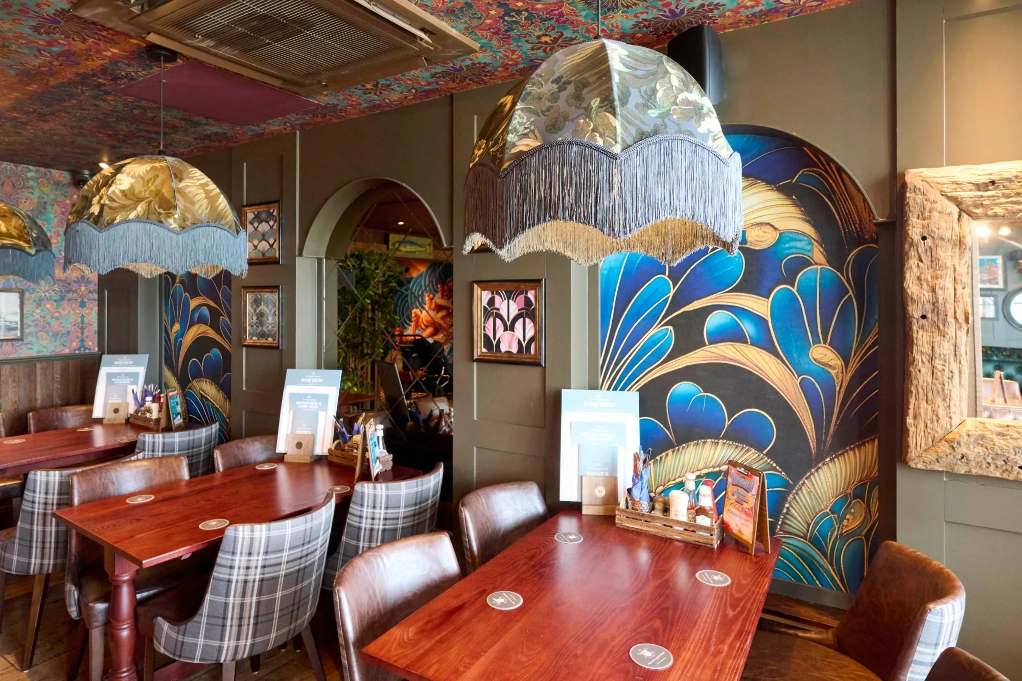 Interior of Tynemouth Castle Inn pub, featuring vintage-inspired wallpaper in wall arches and on the ceiling.