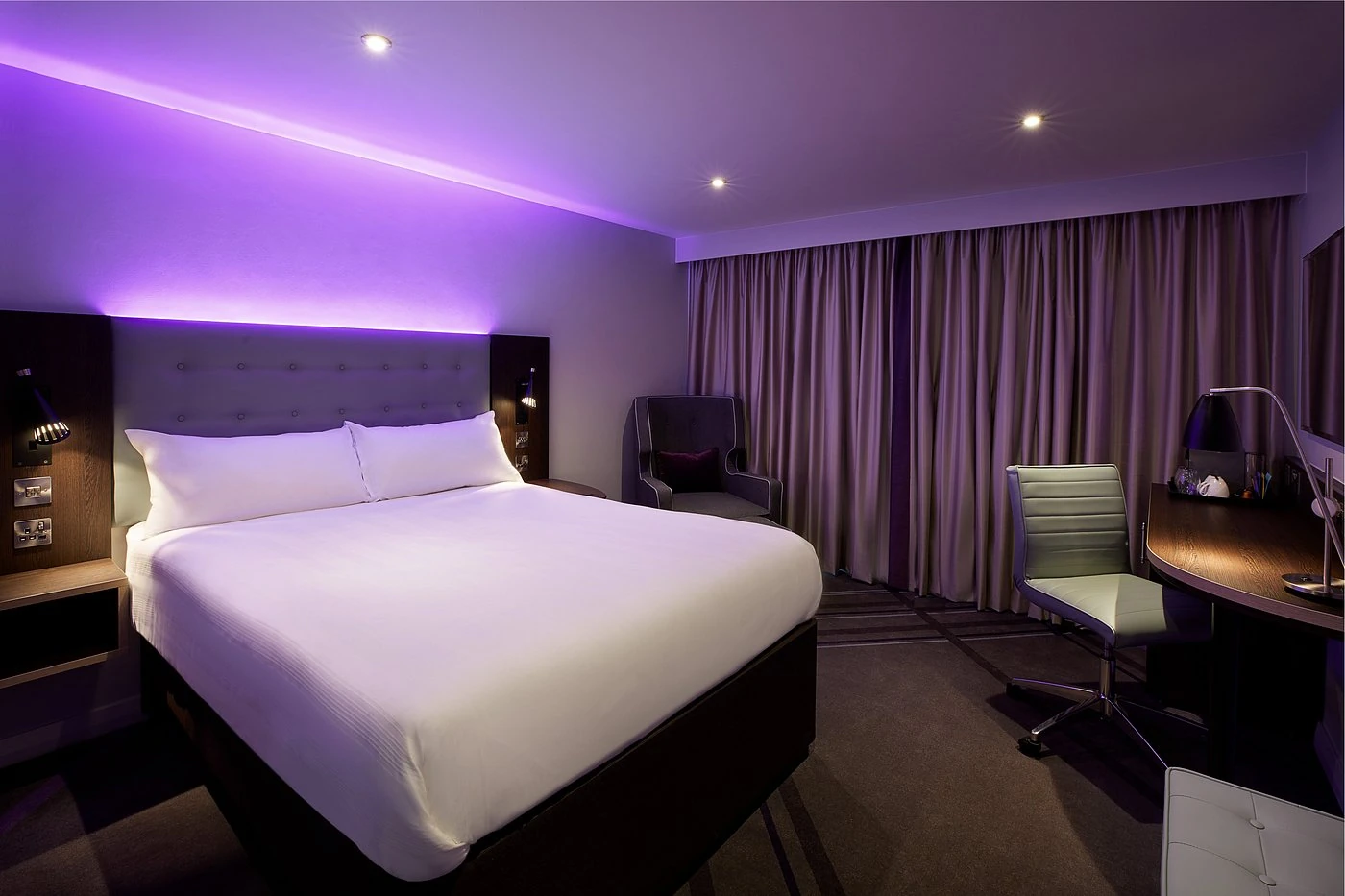 A high-specification Premier Plus bedroom featuring signature purple LED mood lighting and upgraded furnishings.